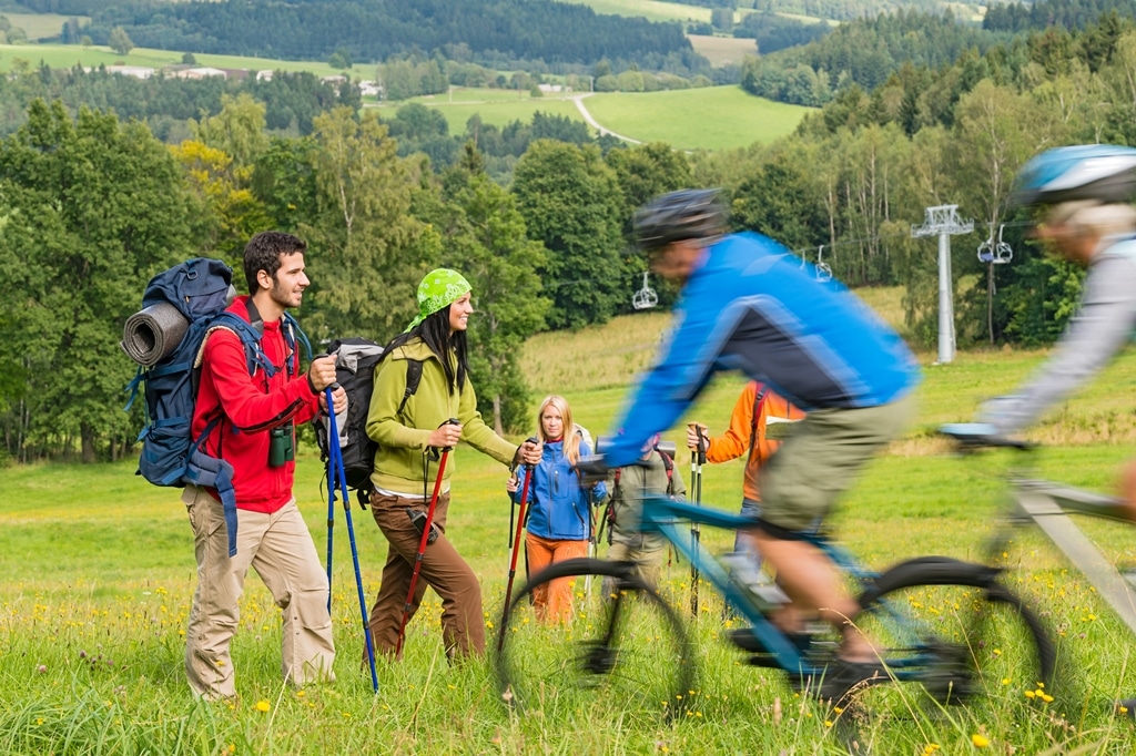 People hiking and riding bikes on summer vacation nature landscape