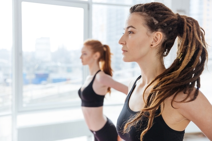 Two young women practicing yoga in studio