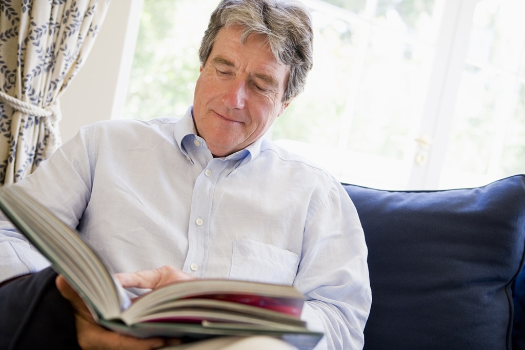 man-relaxing-with-book-in-living-room