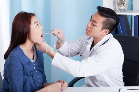 29896789 – asian male doctor examining his female patient